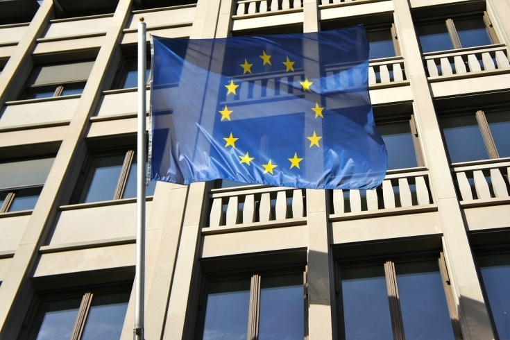 Fot. Yukiko Matsuoka CC by 2.0 Flaga Unii Europejskiej powiewająca na zewnątrz przed budynkiem.